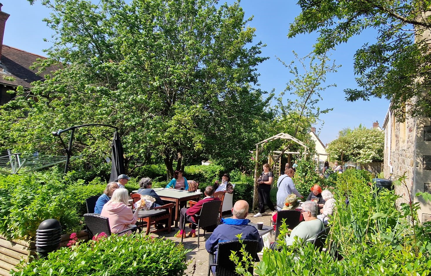 People at the Beehive Centre sit in their new community garden