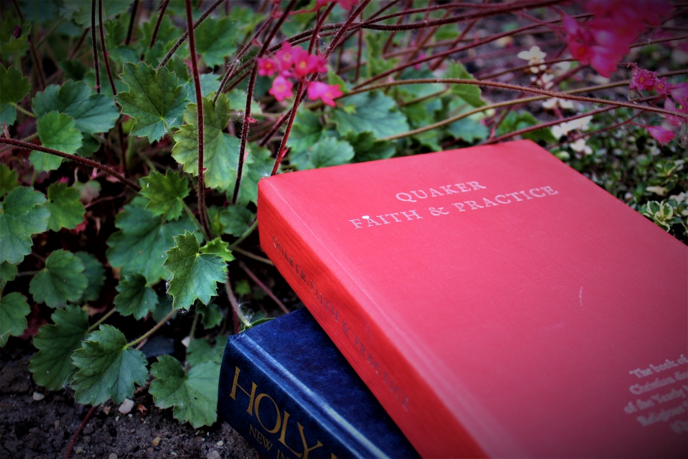 An image of two holy books surrounded by green plants